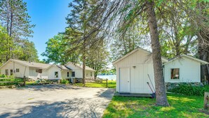 A row of white cabins with a paved driveway, surrounded by trees and greenery. - Pet-friendly Bass Lake Cabin: Beach & Boat Dock (Irons)