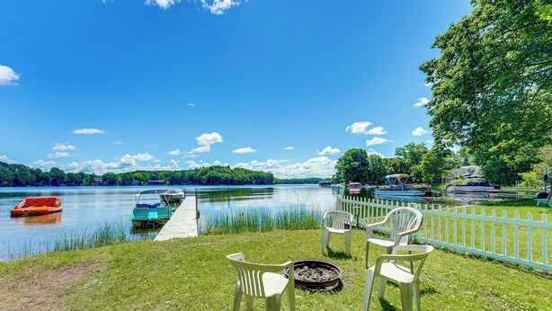 A lakeside setting with a dock, chairs, and a fire pit. - Pet-friendly Bass Lake Cabin: Beach & Boat Dock (Irons)
