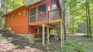 A two-story wooden cabin with a balcony, surrounded by a forest. - Screened Porch w/ Lake View! Tolland Family Haven (Granville)