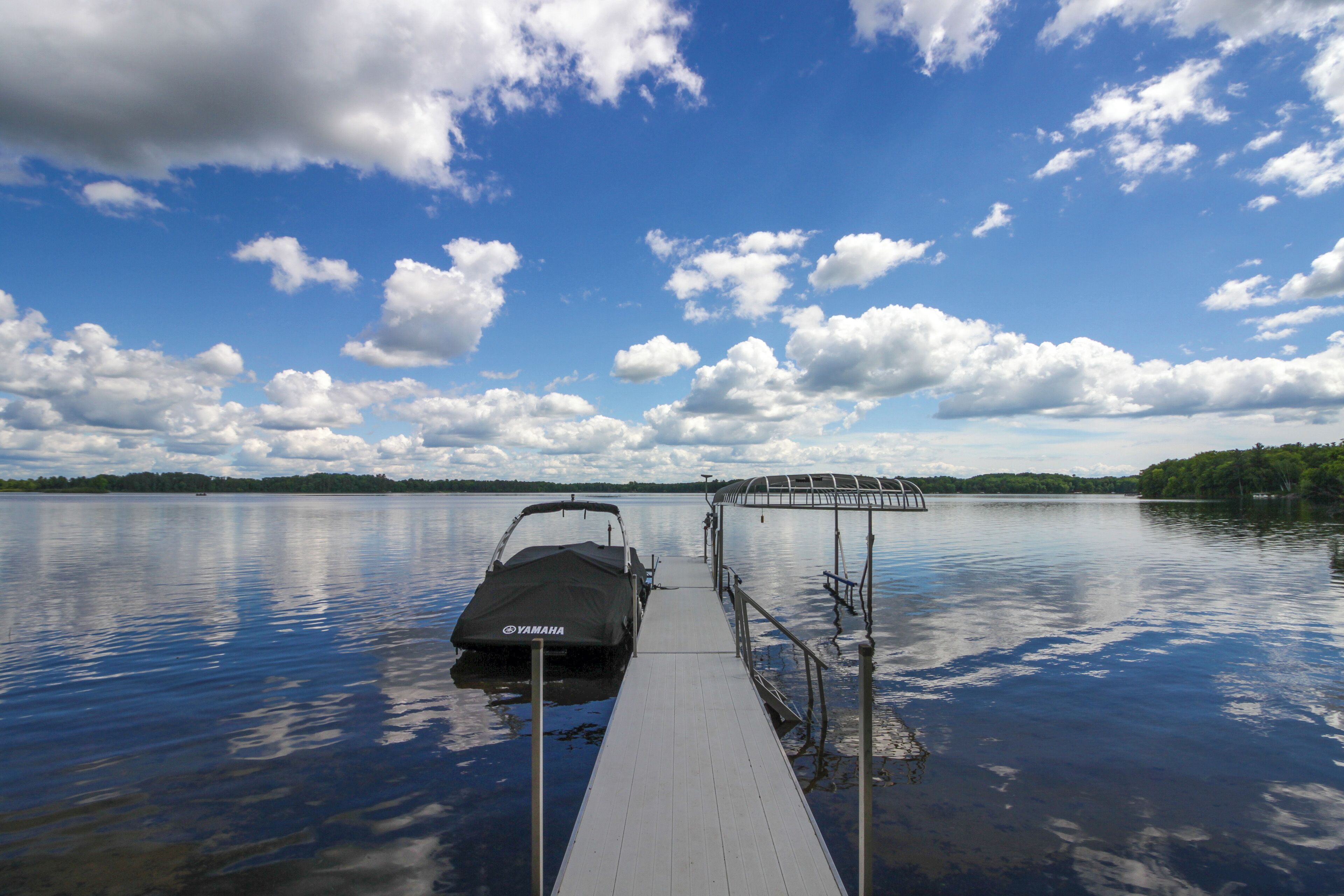 Un bateau était amarré à un quai, sous un ciel dégagé et sur une eau calme.