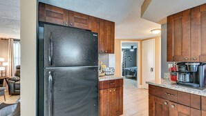 A kitchen with wooden cabinets, a stainless steel refrigerator, and a coffee maker. - Private Pool! Port Richey Home Near Coast & Trails (Port Richey)