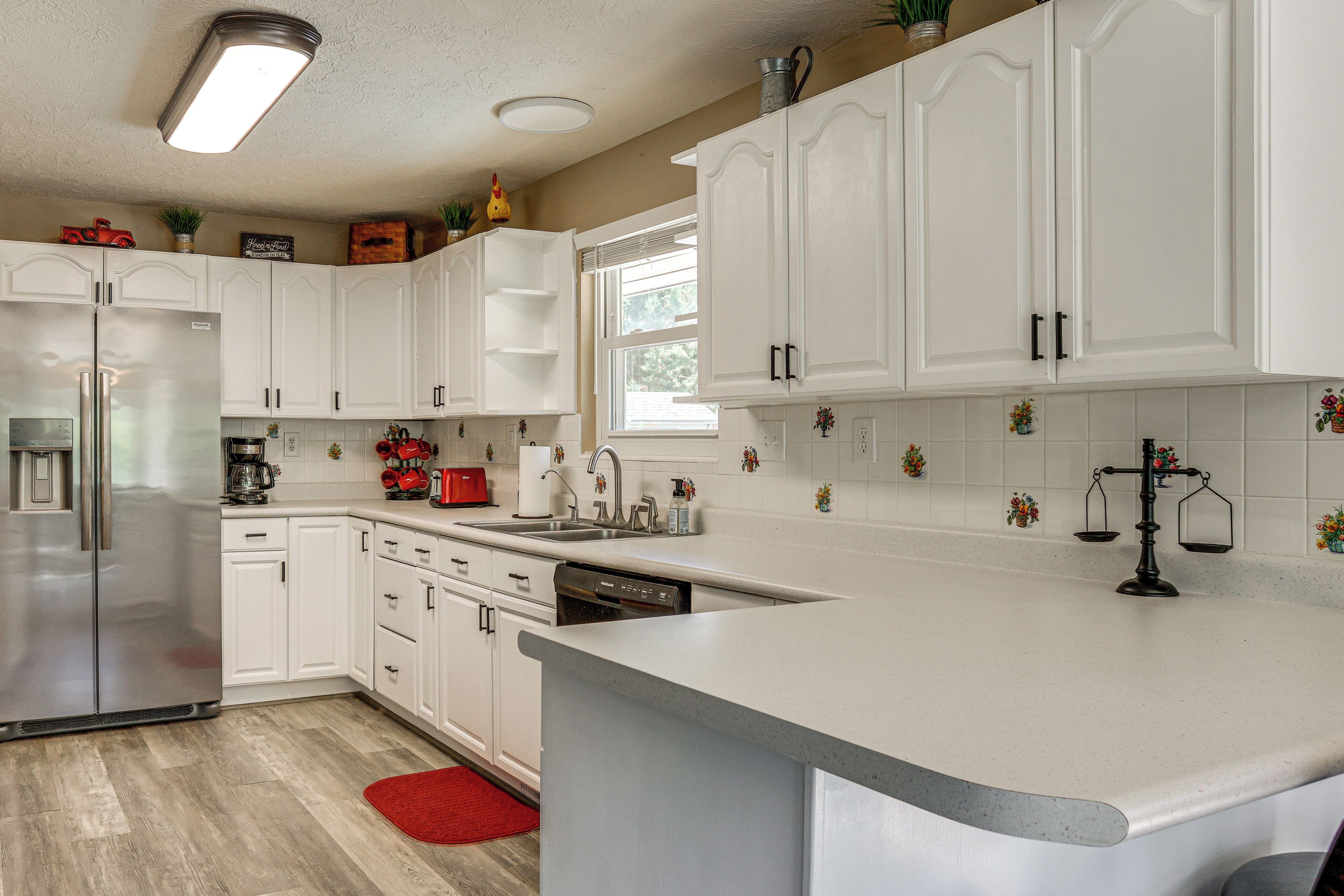 Una cocina moderna con armarios blancos, electrodomésticos de acero inoxidable y una isla grande.