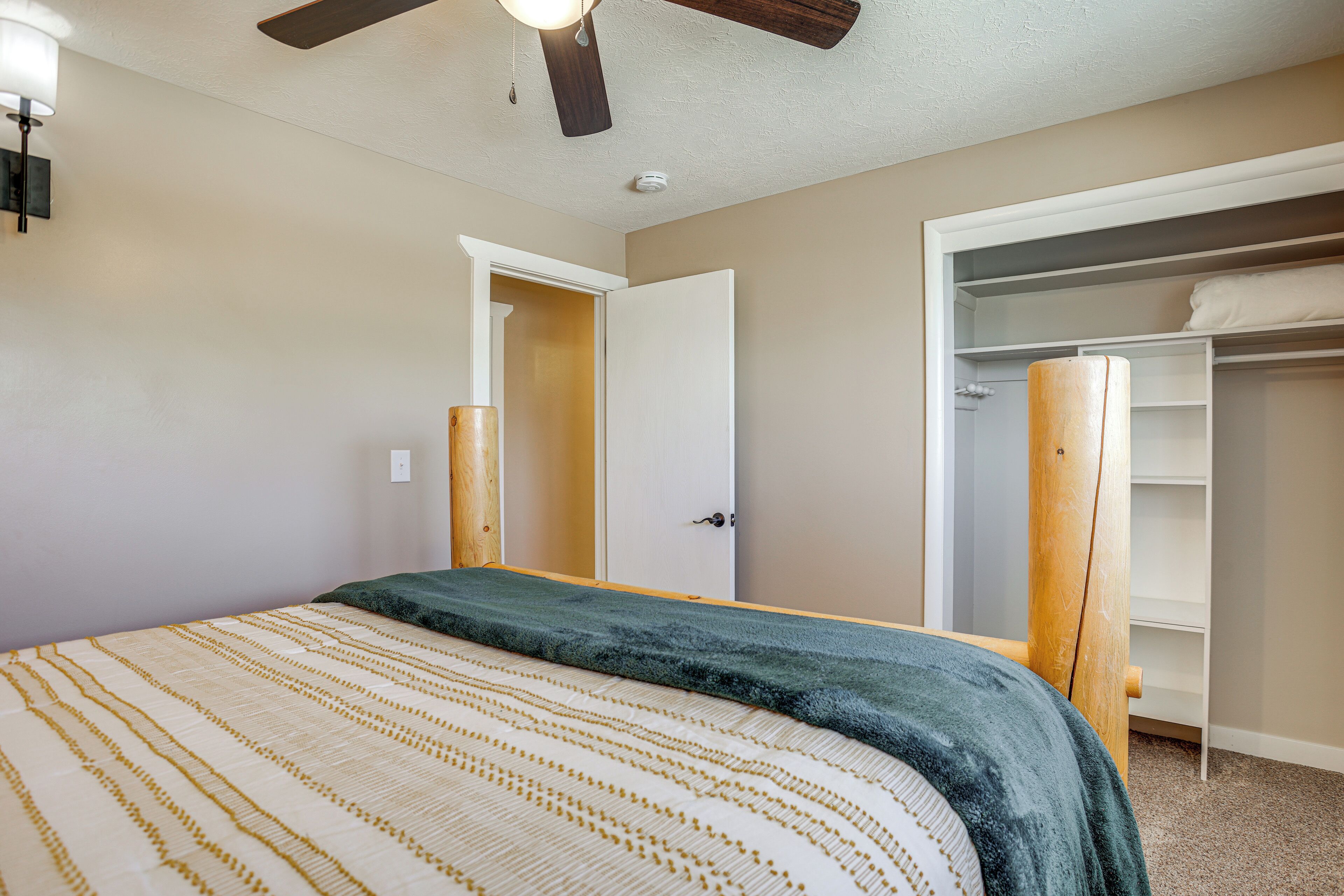 Une chambre à coucher avec un lit, une armoire et un ventilateur de plafond.