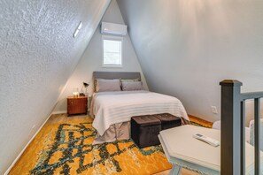 Un dormitorio con cama, mesita de noche y ventana con persianas.