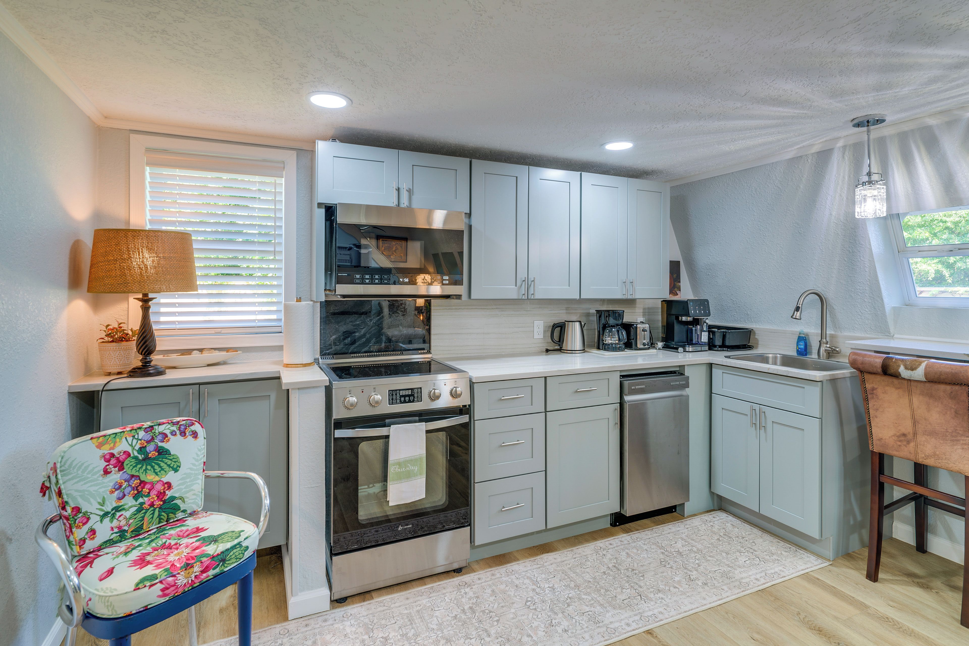 A compact kitchen with a built-in oven, a microwave, a coffee maker, and a dishwasher.
