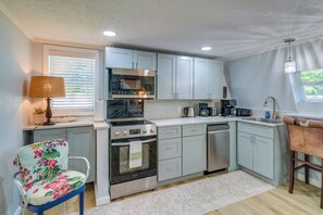 Cocina compacta con horno integrado, microondas, cafetera y lavavajillas.