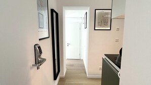 A hallway with a door marked '3', a door marked '1', and a kitchenette area with a countertop and a sink. - Stylish Apartment in Eimsbuettel Hamburg for 4 (Hamburg)