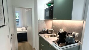 A compact kitchen with a microwave, kettle, and sink. - Stylish Apartment in Eimsbuettel Hamburg for 4 (Hamburg)