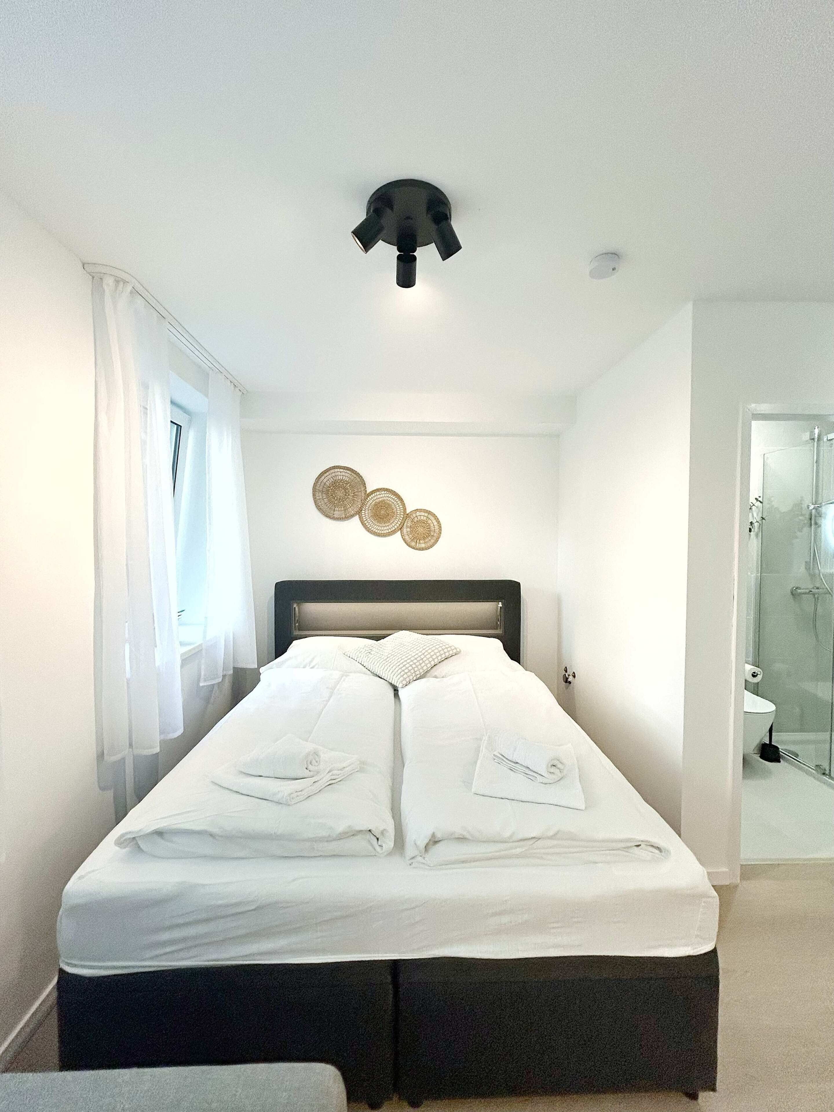 Een hotelkamer met een bed, douche en badkamer.