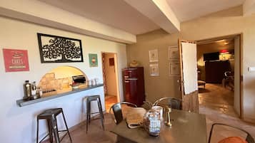 Un espace repas comprenant un comptoir de cuisine, des tabourets de bar et une table à manger.