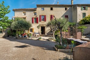Un bâtiment traditionnel doté d’une cour, d’un espace extérieur aménagé pour s’asseoir et d’un sol recouvert de gravier.