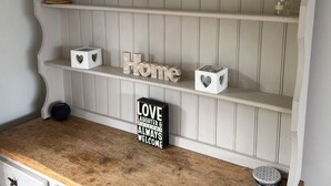 Uno scaffale con oggetti decorativi, un mappamondo e un cartello con scritto 'Love Laughter & Family Always Welcome'.