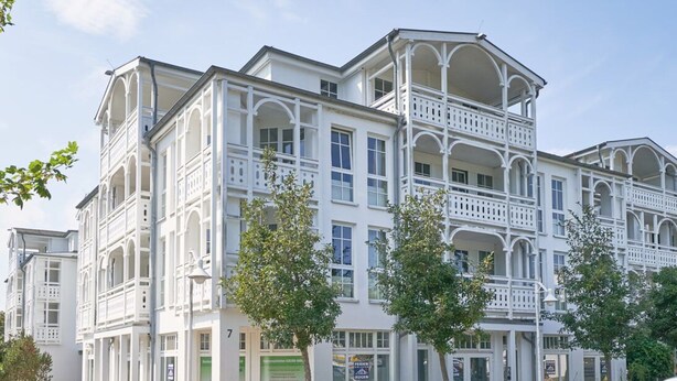 A multi-story building with balconies, a garage, and a sign indicating a restaurant. - Komfortable Ferienwohnung fur bis zu 4 Personen auf Rugen (Sellin)