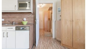 A narrow kitchen with a microwave, sink, and a green bowl on the counter. - Komfortable Ferienwohnung fur bis zu 4 Personen auf Rugen (Sellin)