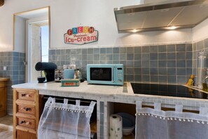 Eine Küche mit Mikrowelle, Toaster und einem Schild, auf dem 'FRESH Handmade Ice-cream' steht.