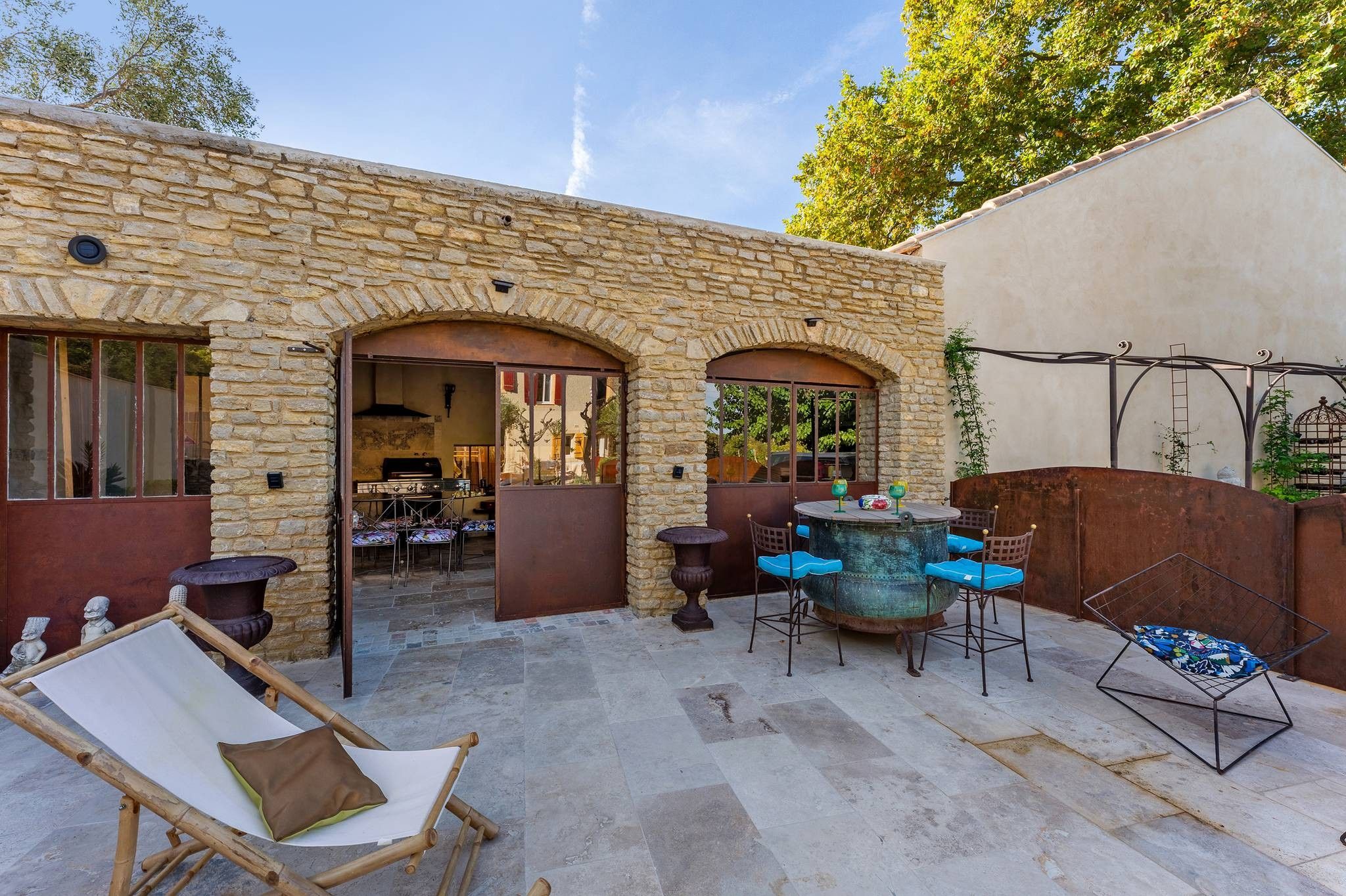Un bâtiment en pierre doté d’un patio ouvert, comprenant un espace de détente en plein air et une fontaine décorative.