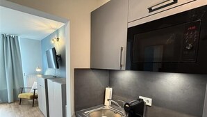 Eine moderne Küche mit Mikrowelle, Spüle und Elektroherd.