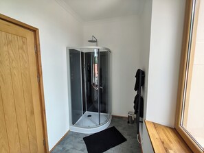 A corner shower room with a glass enclosure, a wooden door, and a black mat on the floor. - 3 double bedroom gite, each with private bathroom in a beautiful location. (Fiménil)