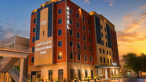 Un hotel de diseño moderno, con un letrero destacado que dice 'Nuzul Al Dabab Hotel' y una escalera que conduce a la entrada.
