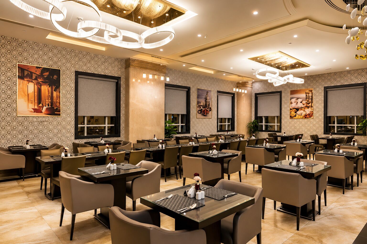 A modern restaurant with multiple dining tables and chairs, decorative wall art, and contemporary lighting fixtures.