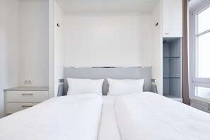 Ein modernes Hotelzimmer mit einem großen Bett, Nachttischen und einem Schrank.