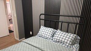 A bed with a metal frame, grey patterned bedding, and plaid pillows. - Cozy farmhouse retreat (Sherwood park)