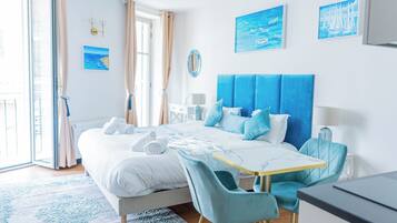 Un dormitorio moderno con cama, escritorio y sillas.