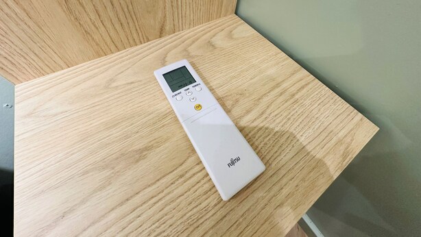 A white portable device on a wooden surface. - Two-Bedroom Condo, Sagrada Familia District (A/C, Kitchen & TV) (Barcelona)
