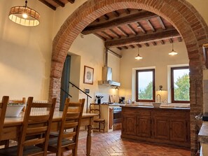 Une cuisine avec une arche en briques, des meubles en bois et une grande fenêtre.