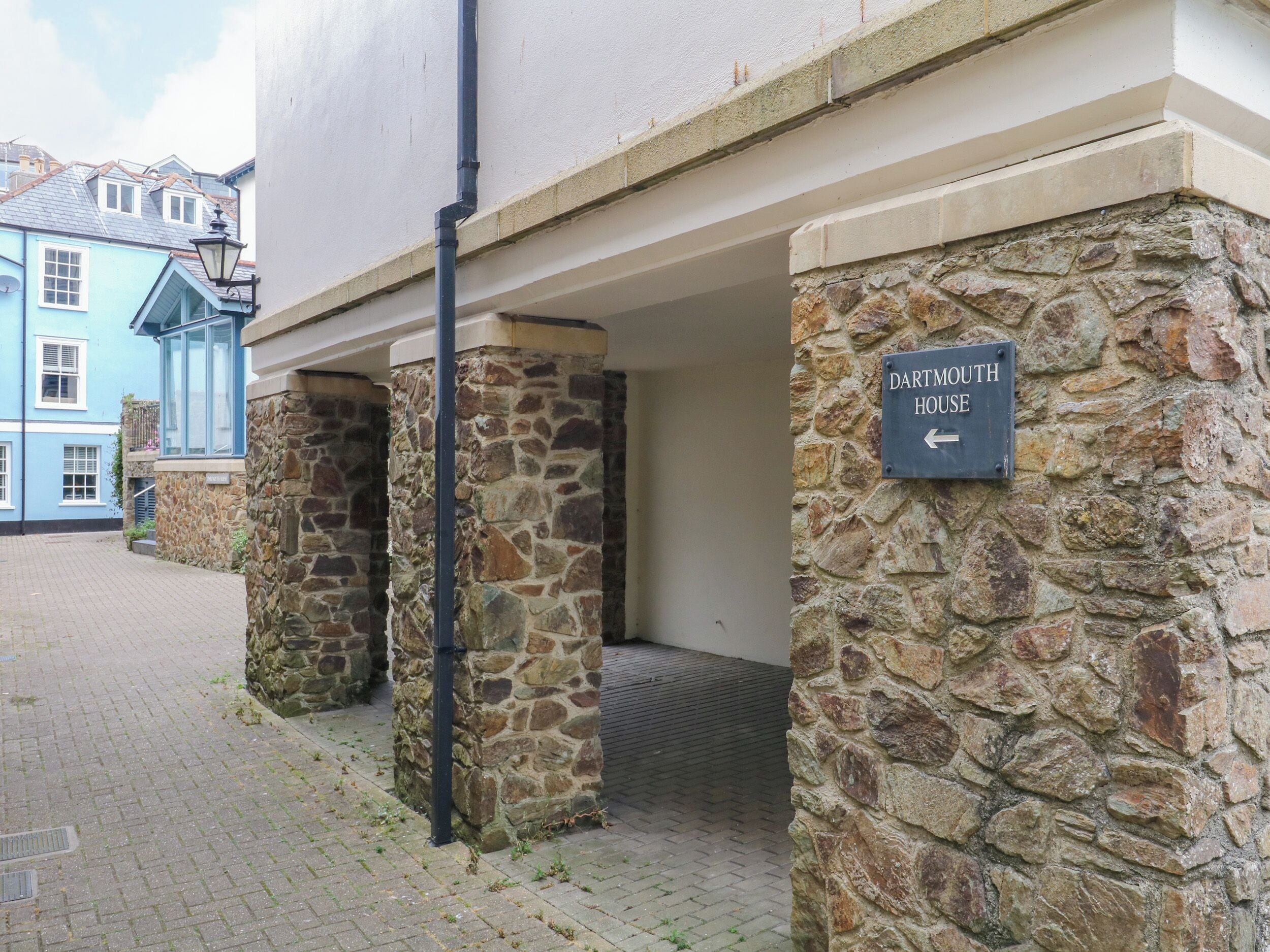 A stone pillar with a sign for 'Dartmouth House' pointing left.