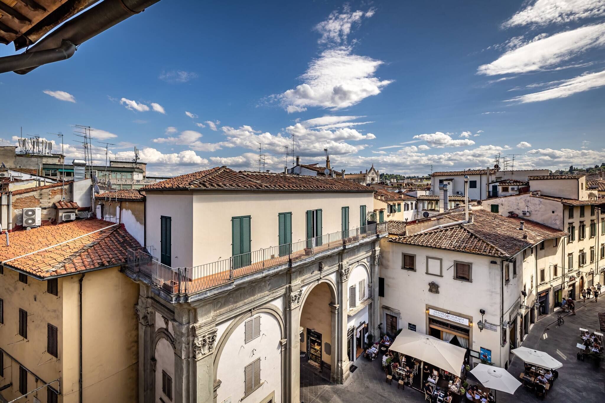 Una plaza histórica con edificios que presentan portales con arcos y techos de tejas.