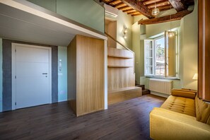 Un interior moderno con una escalera de madera, un sofá y una puerta.