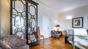 Ein modernes Wohnzimmer mit einem gepolsterten Sessel, einem Glastisch und einer Couch.