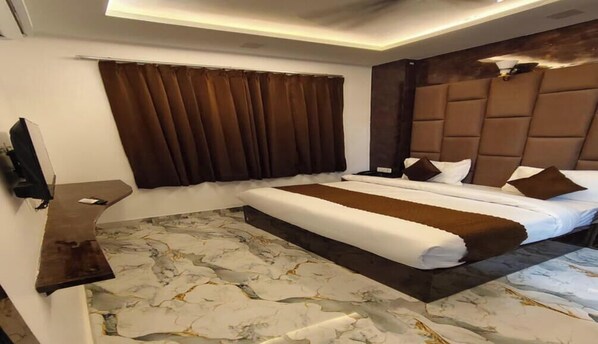 Habitación de hotel con una cama grande, un televisor de pantalla plana y un piso con diseño de mármol.