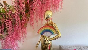Ein Raum mit einer goldenen Statue, einer Couch und einem Tisch.