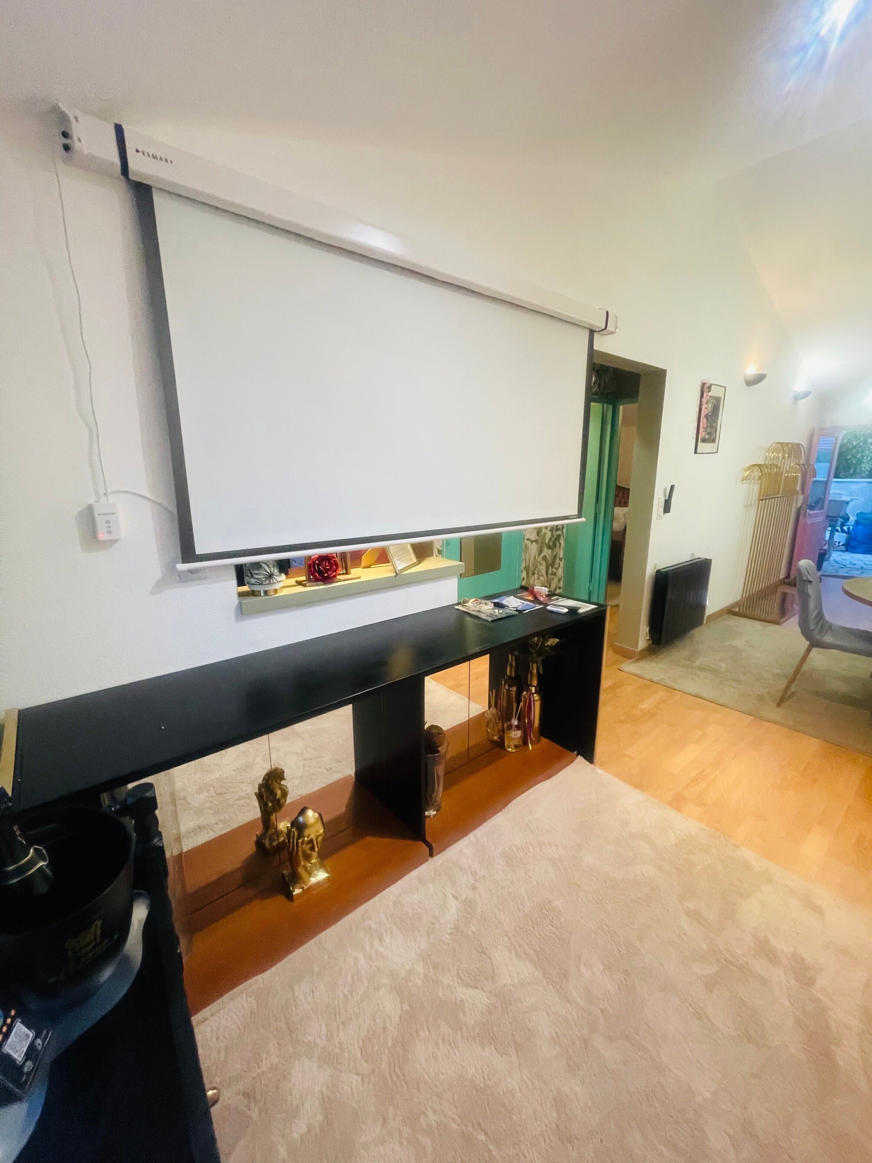A conference room with a whiteboard, a black table with decorative items, and a carpeted floor.