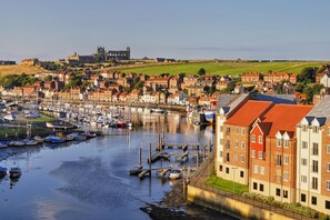 A harbor with boats, a historic building, and residential buildings. - 1 Bed in Whitby (oc-w950) (Whitby)