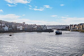 A river with boats, a bridge, and buildings along the banks. - 1 Bed in Whitby (oc-w950) (Whitby)