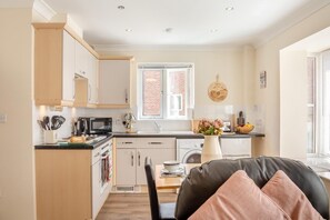 A modern kitchen with white cabinets, a microwave, and a window with a brick wall view. - 1 Bed in Whitby (oc-w815) (Whitby)