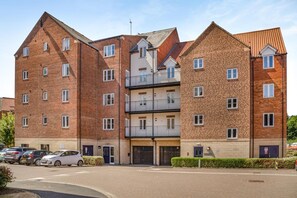 A multi-story residential building with a brick facade, multiple balconies, and a gated entrance. - 1 Bed in Whitby (oc-w815) (Whitby)