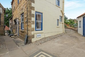 A stone building with a sign indicating private parking for a cottage. - 1 Bed in Whitby (oc-r049) (Robin Hood's Bay)