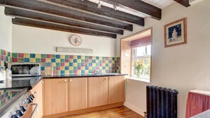 A kitchen with wooden cabinets, a tiled backsplash, a stove, and a window with a view. - 2 Bed in Sleights (oc-wa228a) (Sleights)