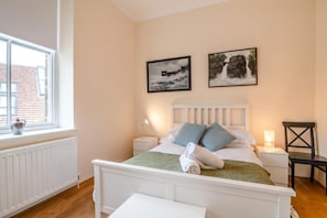 A bedroom with a bed, a nightstand, a chair, a window, and two wall-mounted pictures. - 2 Bed in Richmond (oc-ds187) (Richmond)