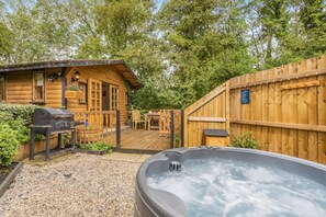 A wooden cabin with a hot tub, a barbecue grill, and a deck. - 1 Bed in Westley Waterless (oc-l34149) (Westley Waterless)