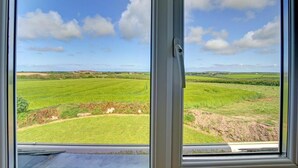 A window with a view of a green field and a clear sky. - 3 Bed in Wadebridge (oc-p00476) (Treburrick)