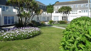 Et boligområde med moderne huse, velplejet græsplæne og blomstrende beplantning.