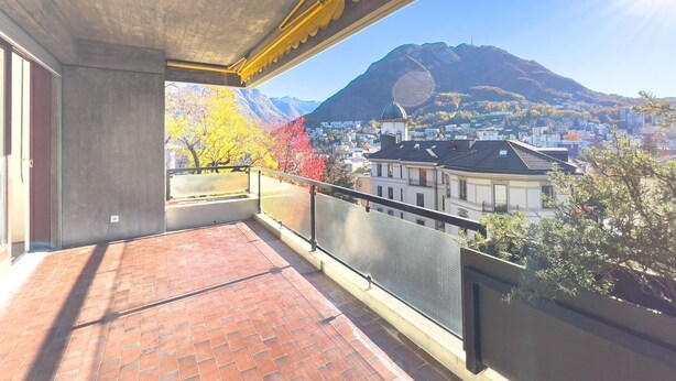 Ein Balkon mit Blick auf ein Gebirge und eine Stadtansicht.