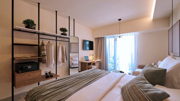 A modern hotel room with a bed, bedside tables, a desk, a TV, and a window with curtains. - Urban Residence: Stylish comfort with city views in the heart of Piraeus. (Pireas)