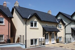A row of modern townhouses with pitched roofs, front porches, and a paved driveway. - 2 Bed in Saundersfoot (oc-pw516a) (Saundersfoot)