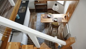 A kitchen with a wooden countertop, a sink, and a dining area with a table and chairs.